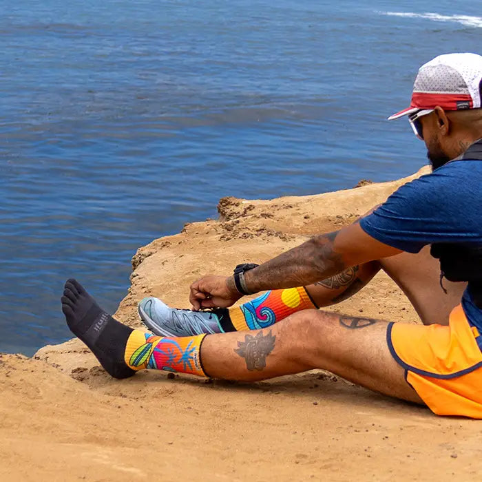 Injinji Trail Midweight Crew Men's Surf (AW25) model in socks putting shoes on