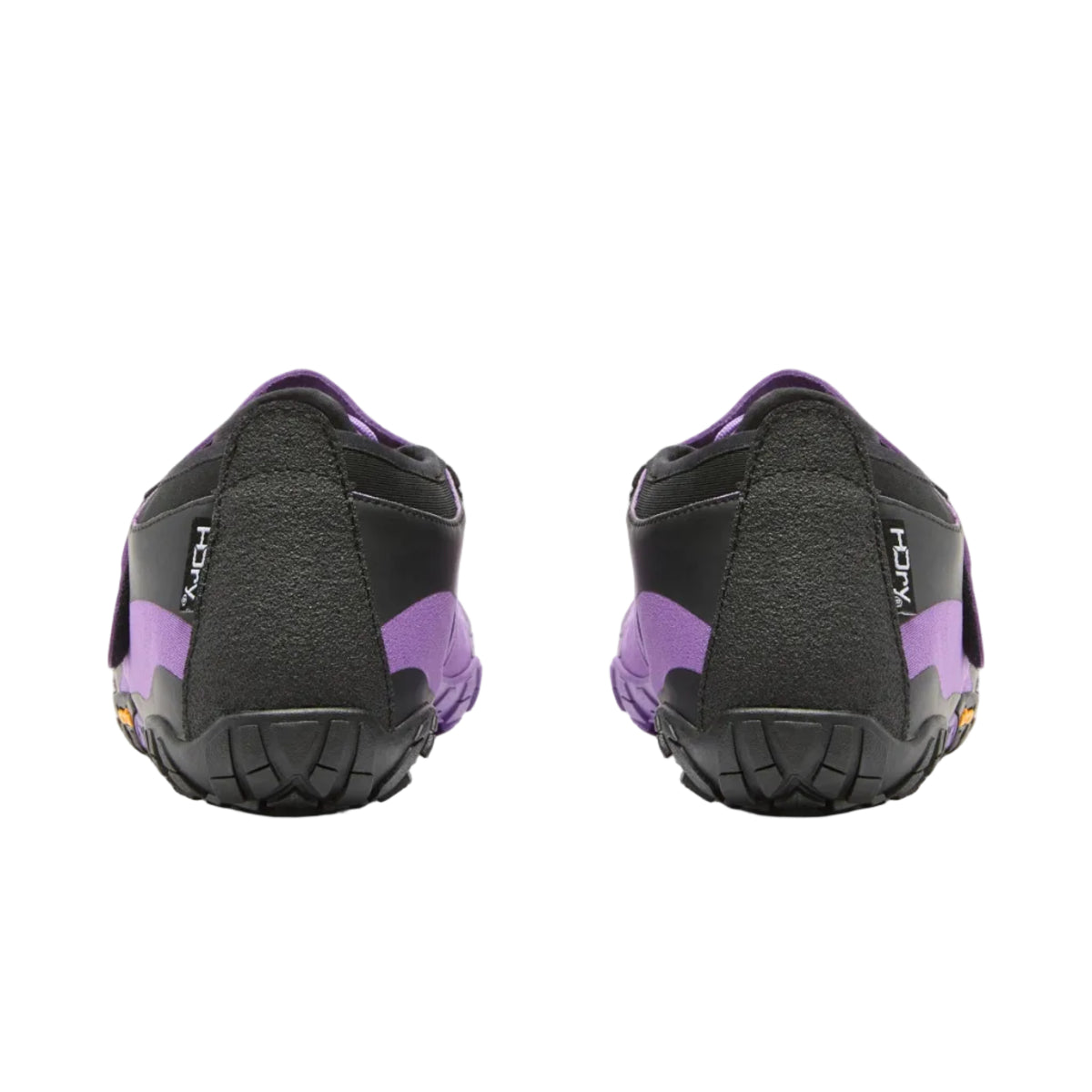 A pair of Vibram shoes shown from the back, featuring a black textured upper with vibrant purple accents on the heel and collar, set against a plain light gray background.